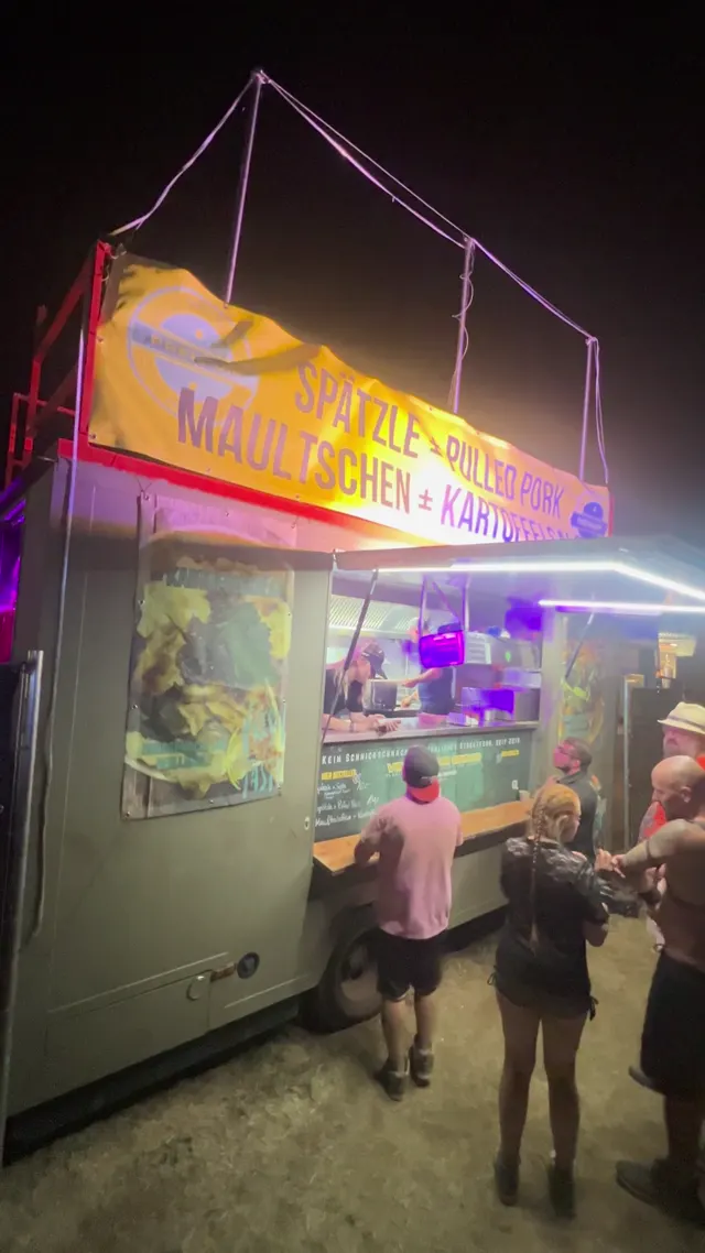 Beleuchteter Häge-Truck bei Nacht, Gäste an der Theke